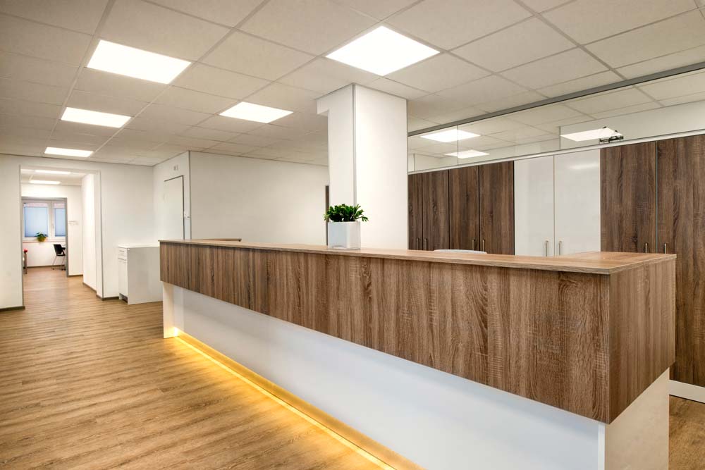 Empfangstresen in Praxis mit dunklem Holzaufbau