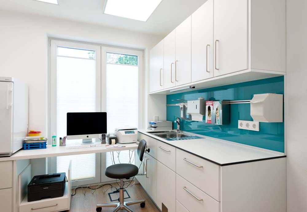 Praxisraum mit Schrankzeile und Schreibtisch