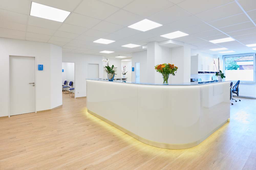 Empfangstresen einer Praxis mit Glas und Lichtanwendung.