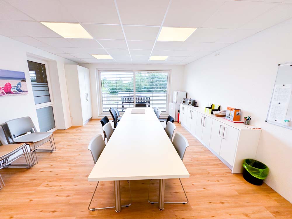 Multifunktionsraum einer Praxis mit langem Tisch im Zentrum.