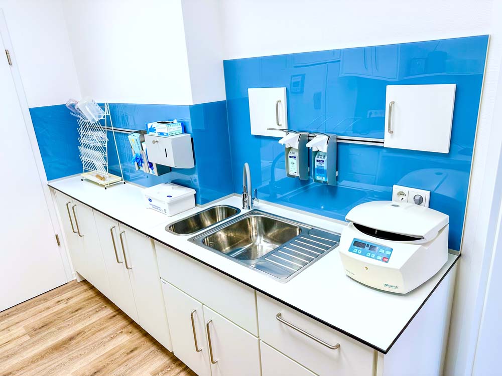 Tiefschrankwand mit integriertem Spültisch und Spritzschutz aus Glas an der Wand.