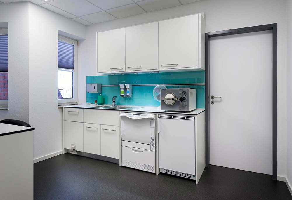 Arbeitszimmer in Praxis. Schrankzeile mit Spülmaschine, Kühlschrank und Spültisch